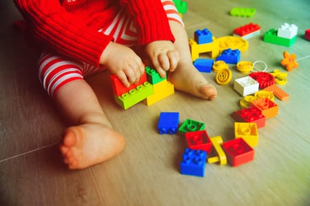 Criança brincando com blocos coloridos
